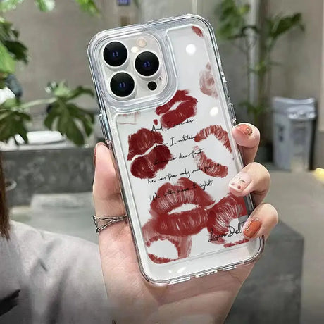 a woman holding a phone case with lipstick prints