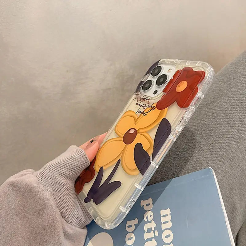 a woman holding a phone case with a cartoon character
