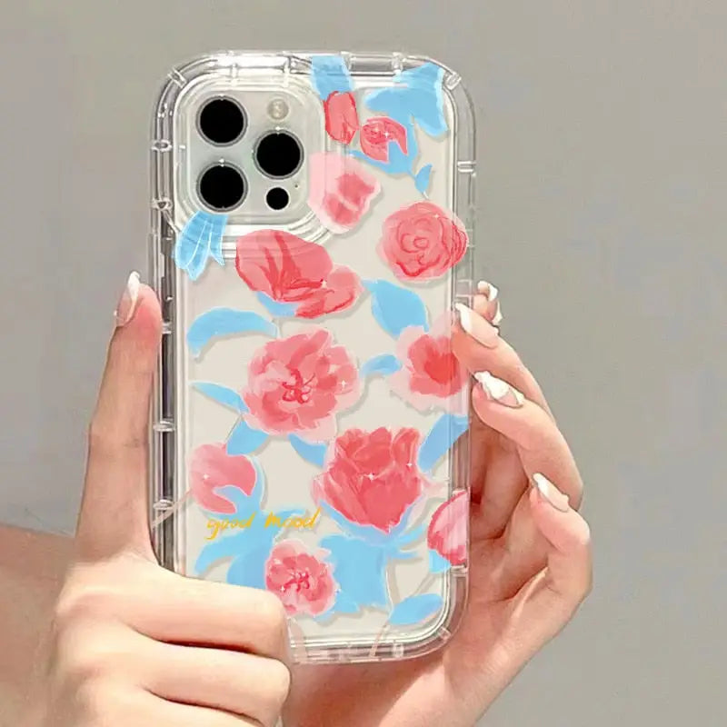 a woman holding a phone case with pink flowers on it