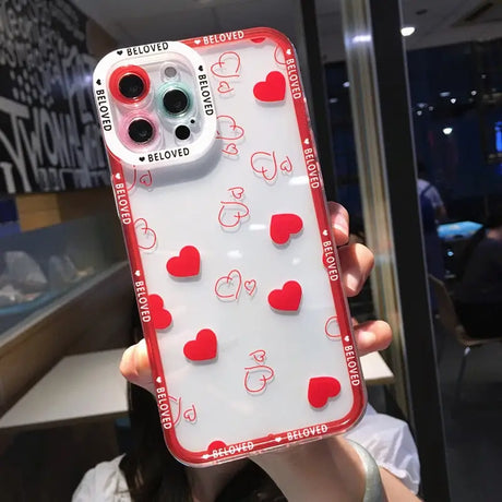 a woman holding up a phone case with hearts on it