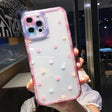 a woman holding a phone case with polka dots