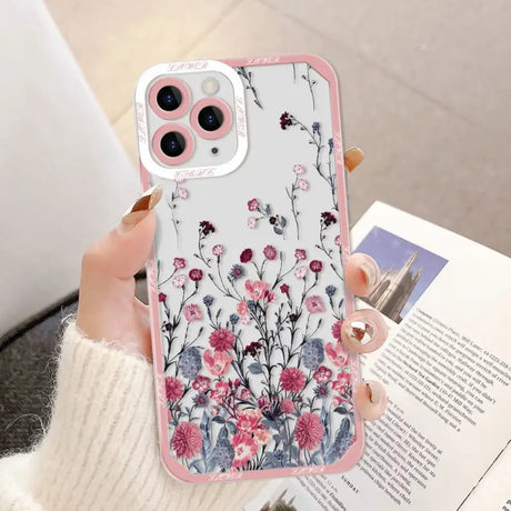 a woman holding a phone case with flowers on it