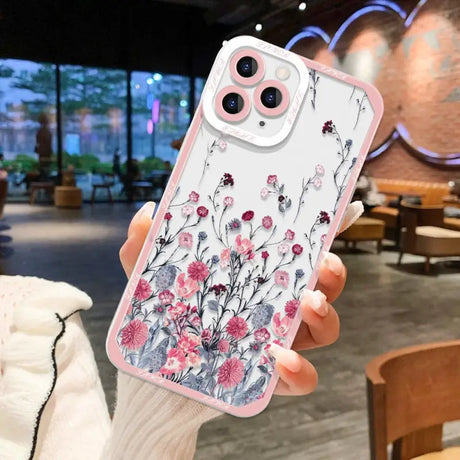 a woman holding a phone case with flowers on it