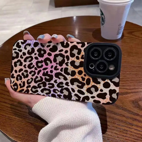 a woman holding a phone case with a leopard print