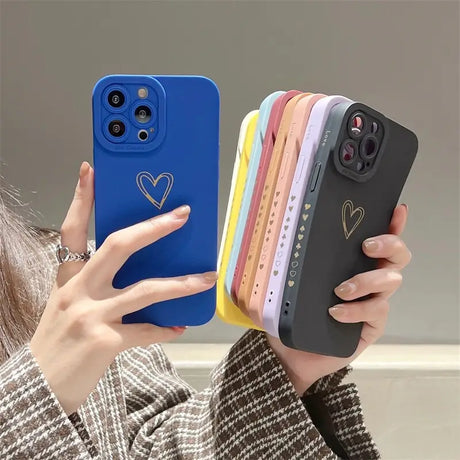 a woman holding a phone case with a heart on it