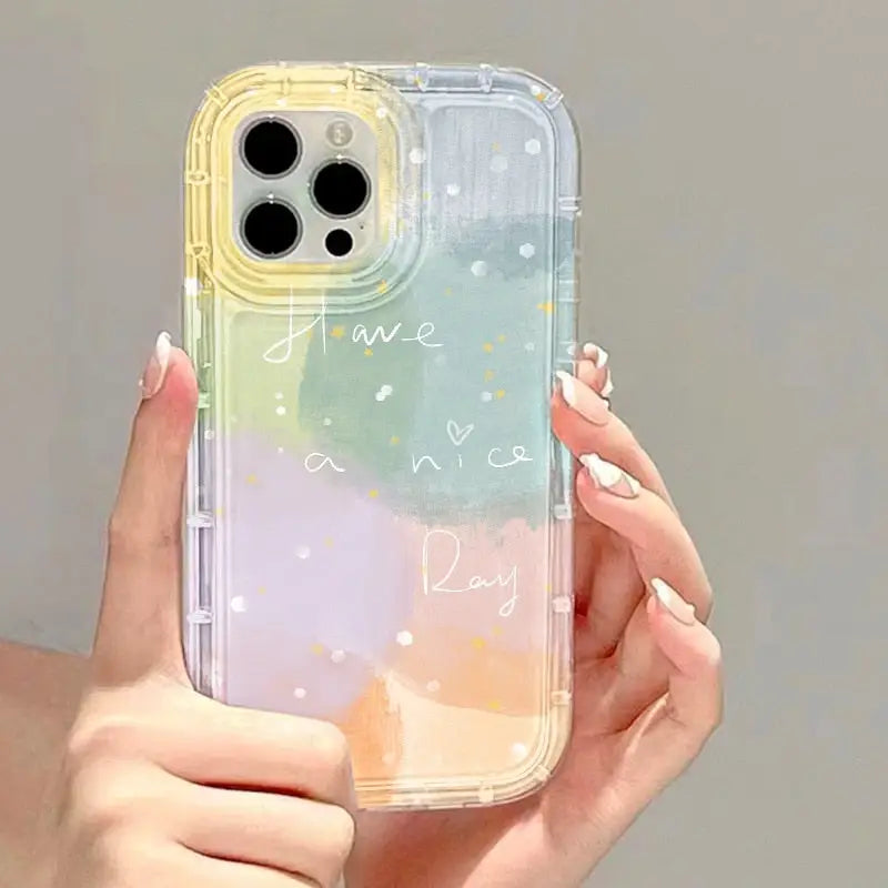 a woman holding a phone case with a watercolor painting on it