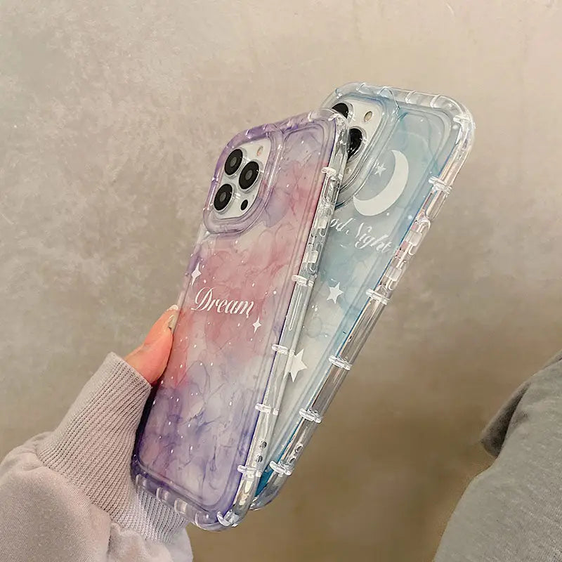 a woman holding a phone case with a watercolor painting on it