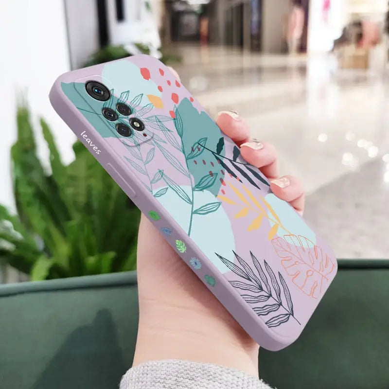 a woman holding a phone case with a floral design