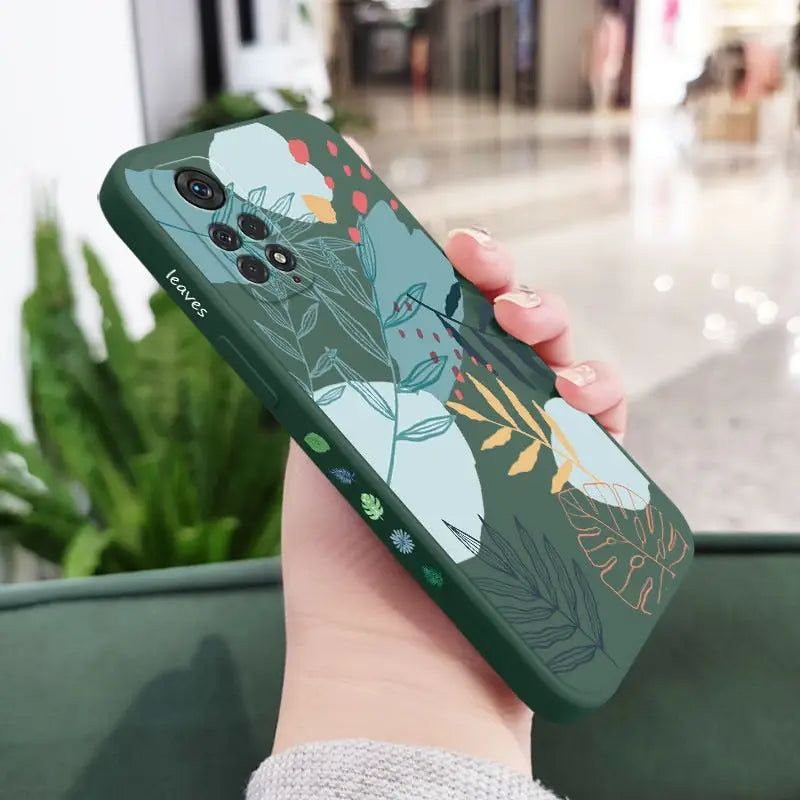 a woman holding a phone case with a floral pattern