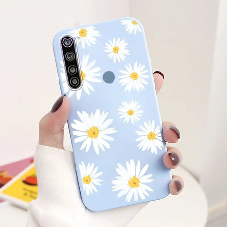 a woman holding a phone case with a flower pattern on it