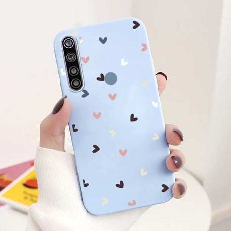 a woman holding a phone case with hearts on it