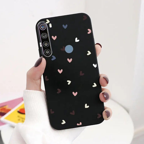 a woman holding a phone case with hearts on it