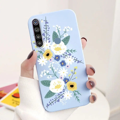 a woman holding a phone case with flowers on it