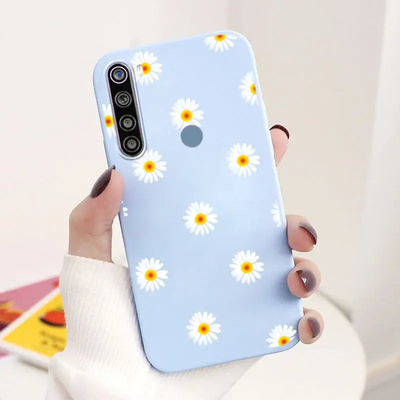 a woman holding a phone case with a daisy pattern on it