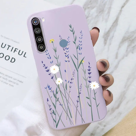 a woman holding a phone case with flowers on it