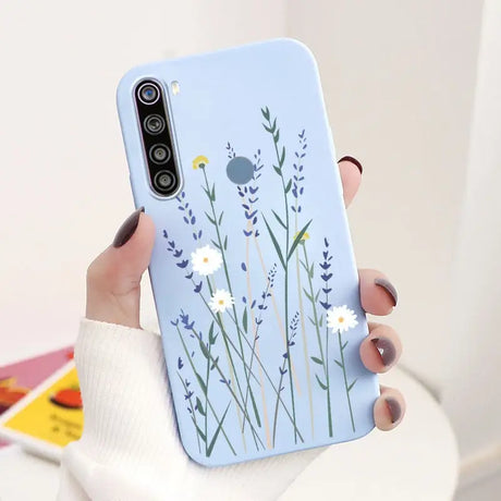 a woman holding a phone case with flowers on it