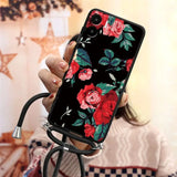 a woman holding a phone case with flowers on it