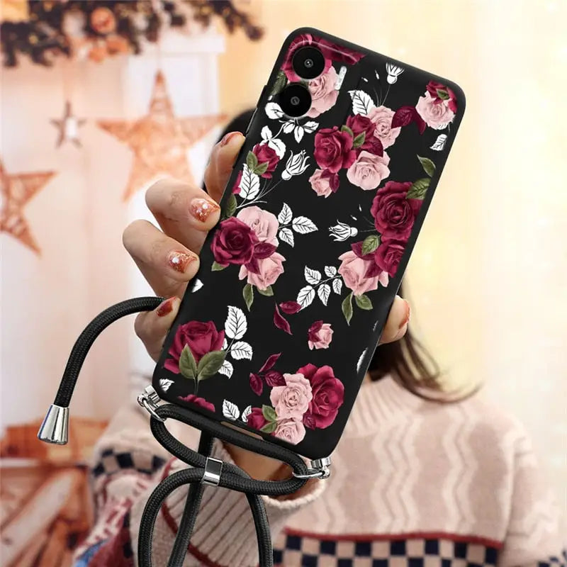 a woman holding a phone case with flowers on it