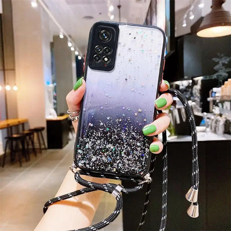 a woman holding a phone case with glitter on it