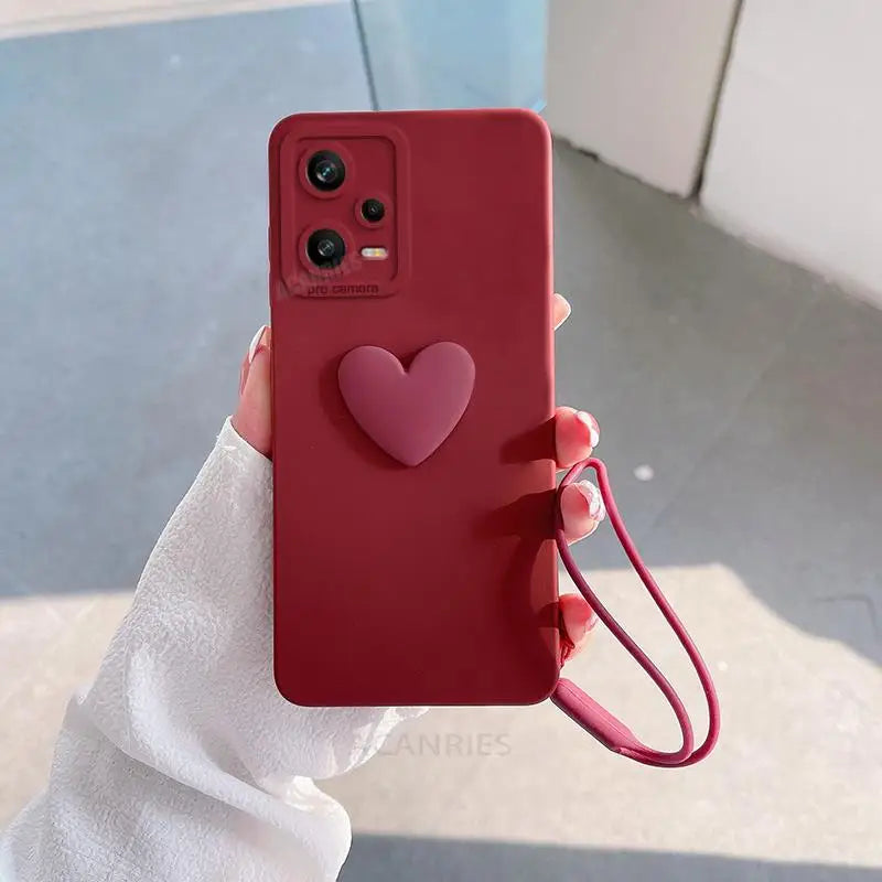 a hand holding a red phone case with a heart on it