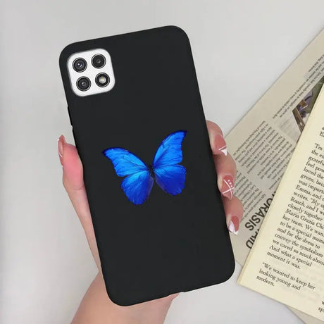 a woman holding a phone case with a blue butterfly on it