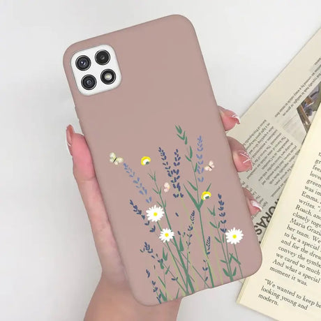 a woman holding a phone case with flowers on it