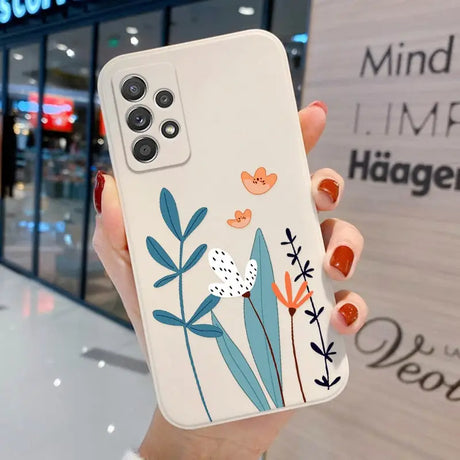 a woman holding a phone case with flowers on it