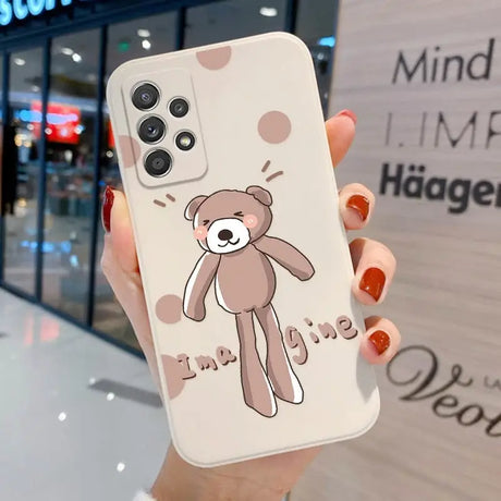 a woman holding a phone case with a teddy bear