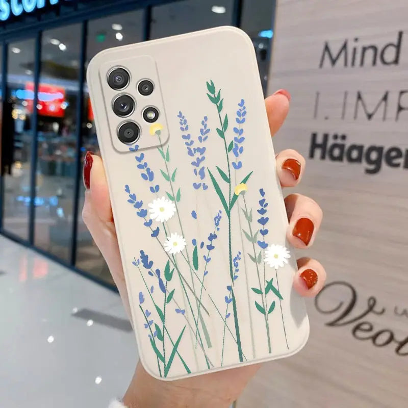 a woman holding a phone case with flowers painted on it