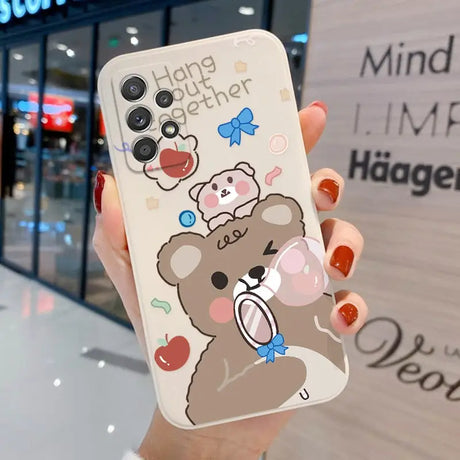 a woman holding a phone case with a bear on it