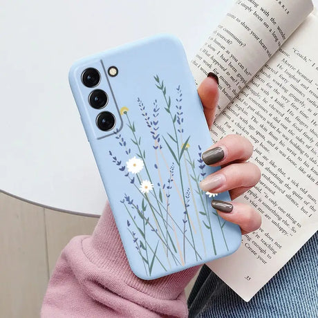 a woman holding a phone case with a flower design