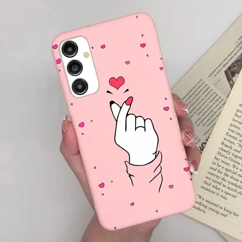 a woman holding a pink phone case with a heart on it