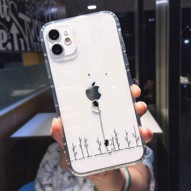 a woman holding up a white phone case with a black and white drawing of a bird on it