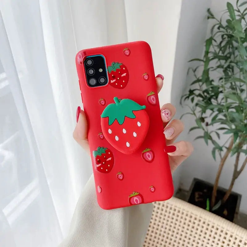 a woman holding a red phone case with strawberries on it