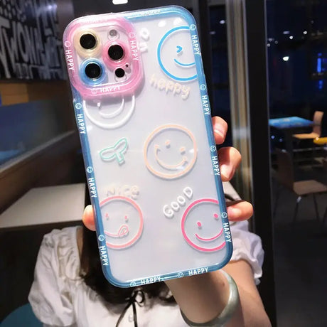 a woman holding up a phone case with smiley faces