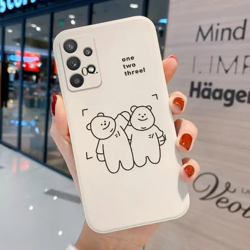 a woman holding up a phone case with a drawing of two bears