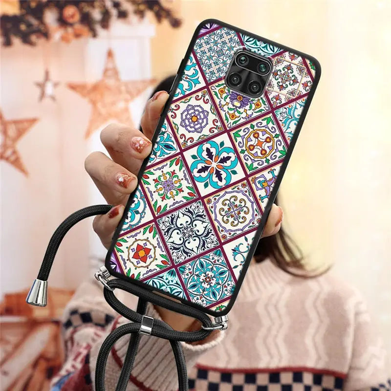 a woman holding a phone case with a colorful pattern