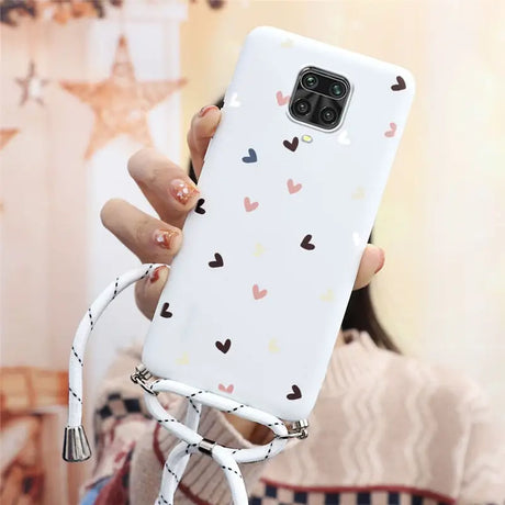 a woman holding a phone case with hearts on it