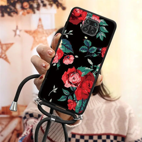 a woman holding a phone case with flowers on it