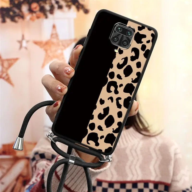 a woman holding a phone case with a black and white cow print