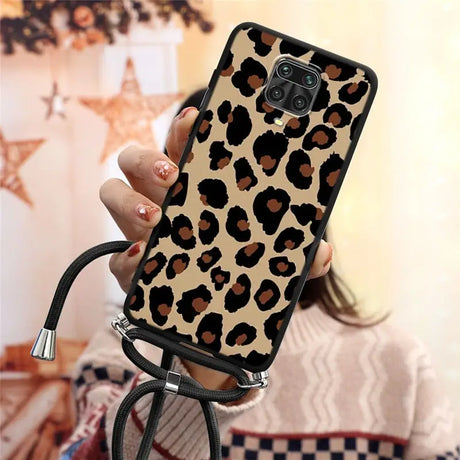 a woman holding a phone case with a leopard print