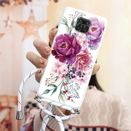 a woman holding a phone case with flowers on it