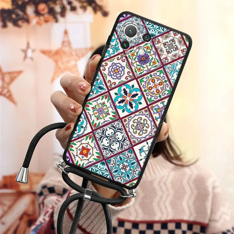a woman holding a phone case with a colorful pattern
