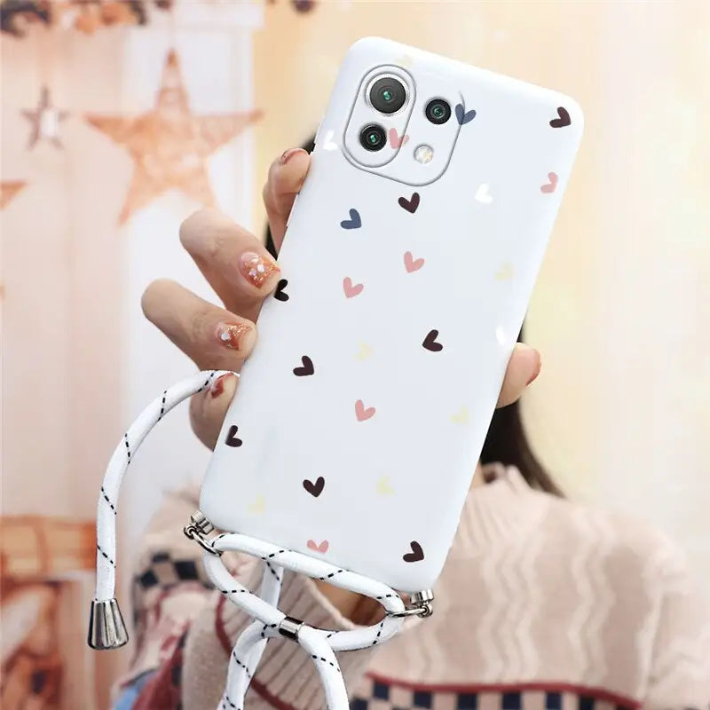 a woman holding a phone case with hearts on it