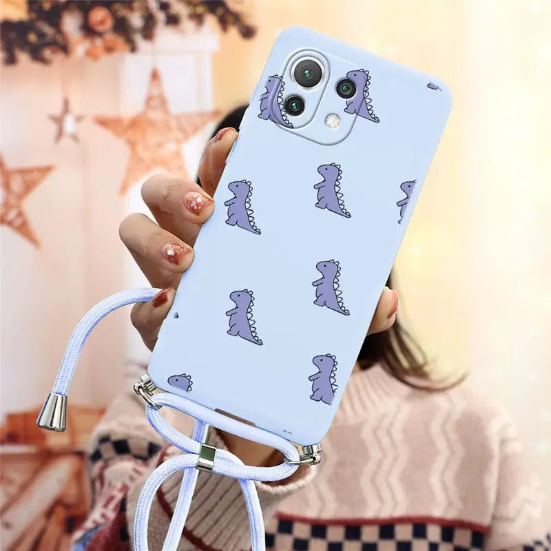 a woman holding a phone case with a pattern of dinosaurs