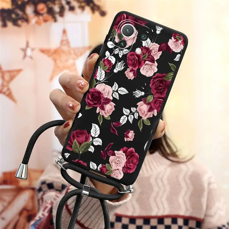 a woman holding a phone case with flowers on it