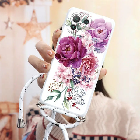 a woman holding a phone case with flowers on it