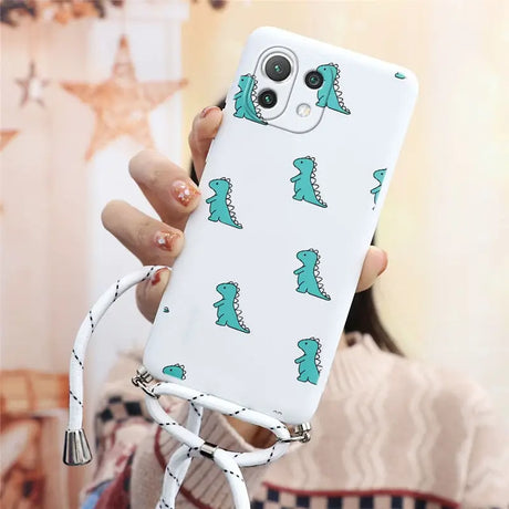 a woman holding a phone case with a green dinosaur pattern