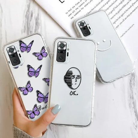 a woman holding a phone case with purple butterflies on it