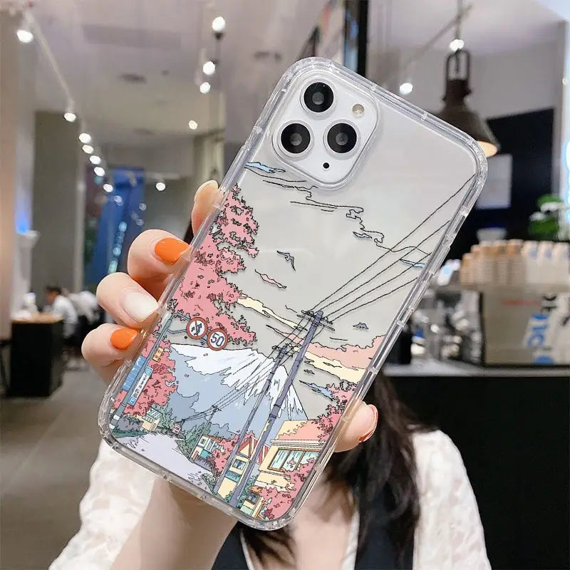 a woman holding up a phone case with a drawing of a city